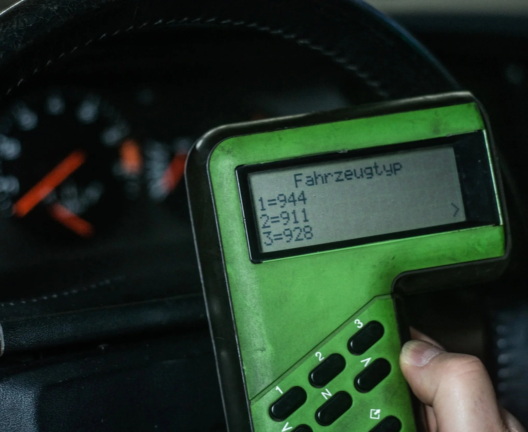 Bosch Systemtester 9288 in der Hand, auf dem Display die Auswahl Fahrzeugtyp 944, 911 und 928